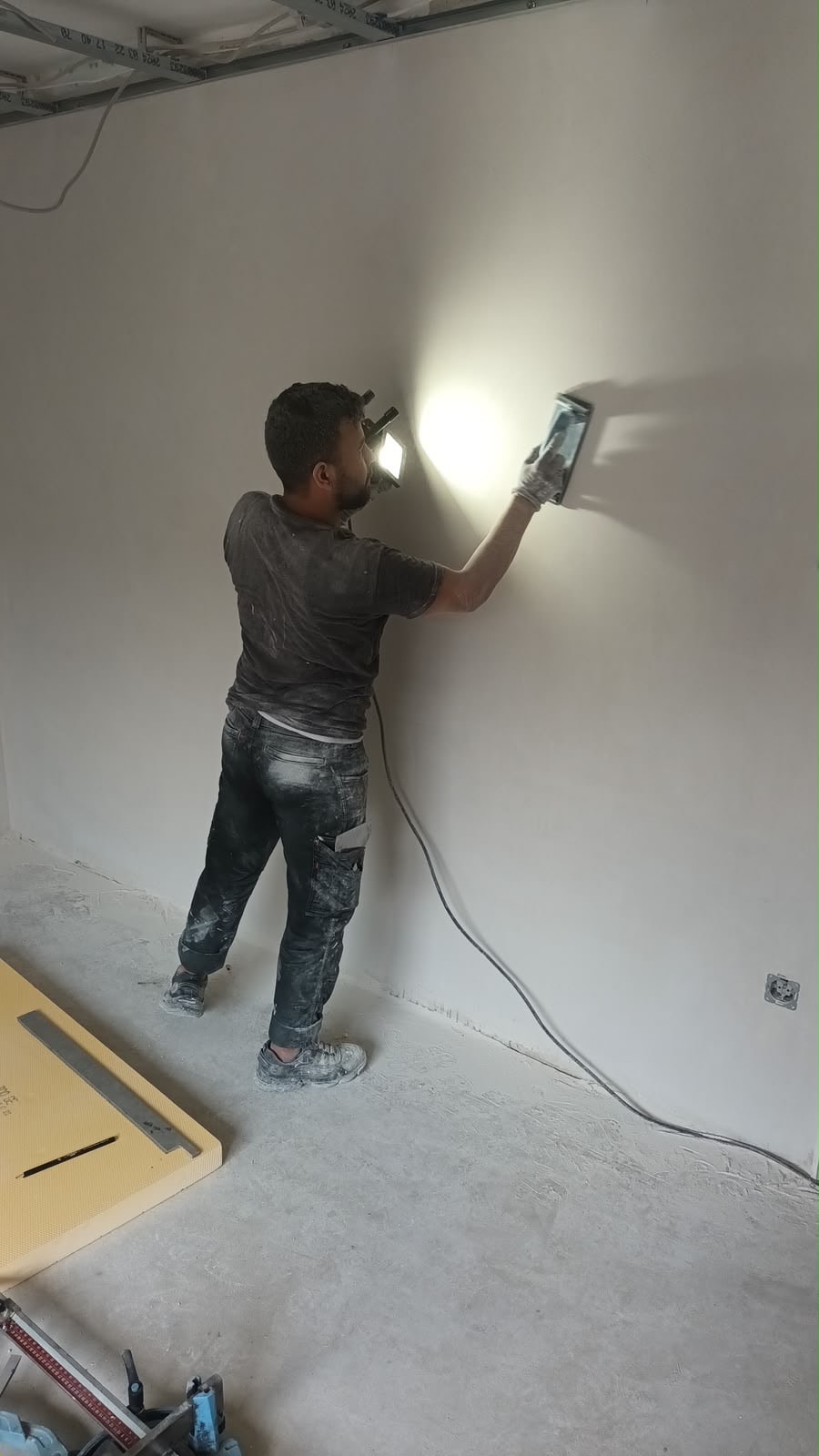 Mitarbeiter beim Schleifen der Trockenbau-Wand